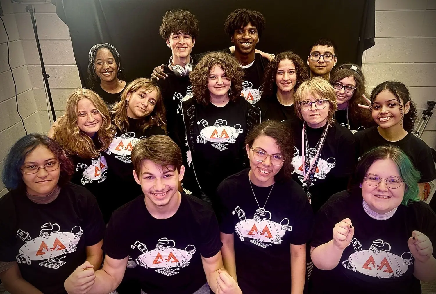 Students from the Academy of Entertainment Arts together in matching shirts.