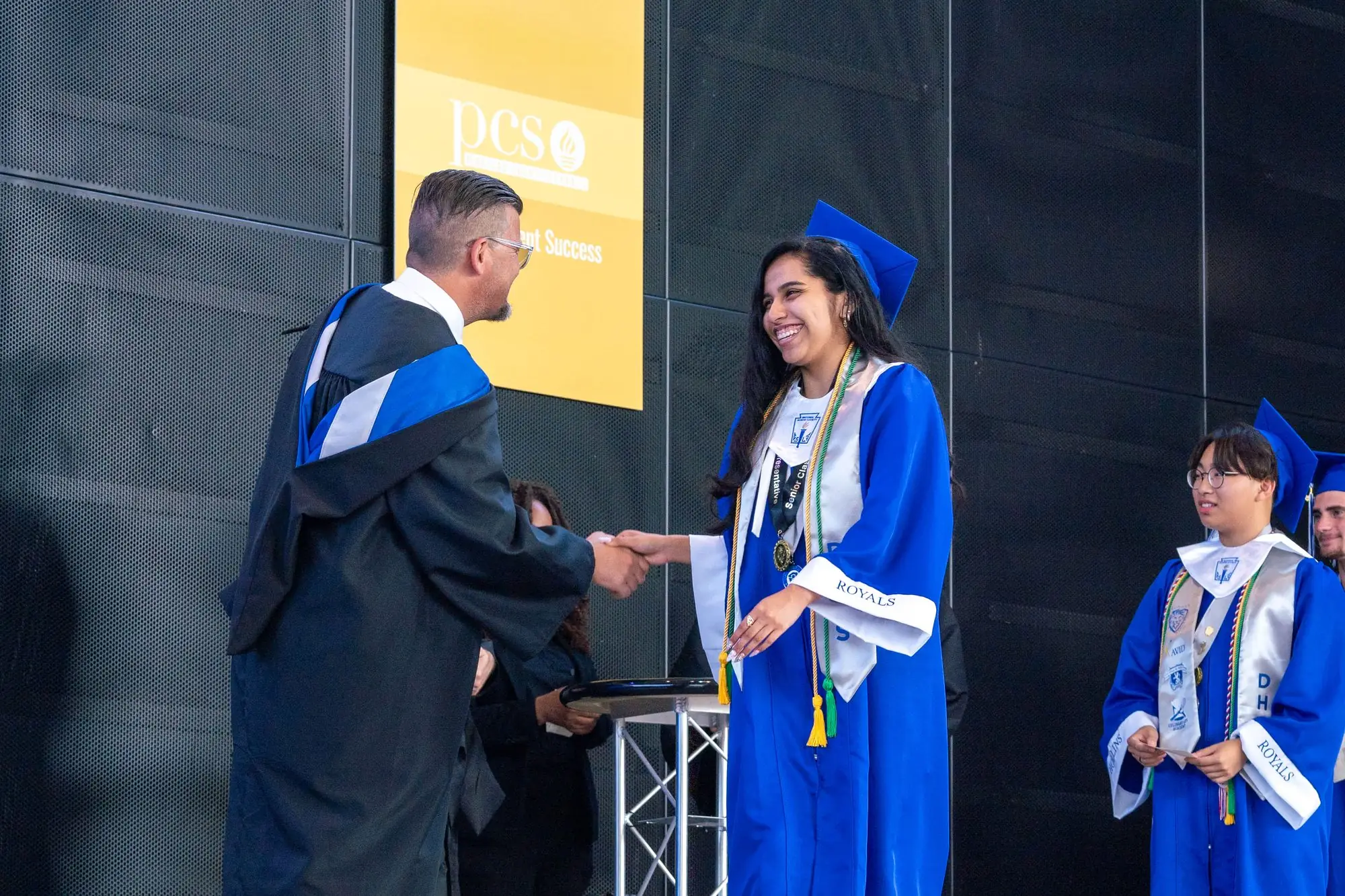 A Hollins graduate is congratulated on stage at commencement.